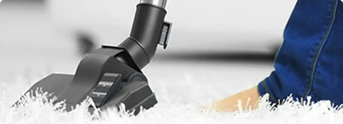 Close-up of a professional vacuuming a white carpet in Sparks.